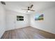 Bright bedroom with wood floors, ceiling fan, and two windows at 31 Oberlin Rd, Venice, FL 34293