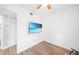 Cozy bedroom with hardwood floors, ample lighting, and a modern wall-mounted television at 31 Oberlin Rd, Venice, FL 34293