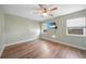 Well-lit bedroom features a ceiling fan, wood floors, and a TV for entertainment and relaxation at 31 Oberlin Rd, Venice, FL 34293