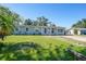 Charming single-story home with a well-manicured lawn, mature trees, and a cozy front porch at 31 Oberlin Rd, Venice, FL 34293