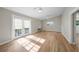 Spacious living room featuring hardwood floors, double ceiling fans, and outdoor access through French doors at 31 Oberlin Rd, Venice, FL 34293