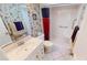 This bathroom features a shower, vanity with floral wallpaper and a mirrored medicine cabinet at 311 Garvin St # 405A, Punta Gorda, FL 33950
