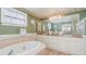 Bathroom with a large mirror, double sinks, a soaking tub, decorative wall paper and a window at 3228 Purple Martin Dr # 116, Punta Gorda, FL 33950