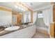 Bright bathroom with marble countertops, double sinks, and a glass enclosed shower with white curtains at 3228 Purple Martin Dr # 116, Punta Gorda, FL 33950