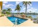 Community pool with lounge chairs, palm trees, and waterfront views at 3228 Purple Martin Dr # 116, Punta Gorda, FL 33950