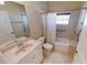 Well-lit bathroom with a single sink vanity, toilet, and bathtub featuring a shower curtain and grab bars at 327 Monaco Dr # 12, Punta Gorda, FL 33950