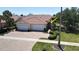 Charming single-story home featuring a well-kept lawn, landscaping, and a brick driveway leading to a two-car garage at 327 Monaco Dr # 12, Punta Gorda, FL 33950