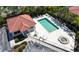 An aerial view of a community pool with lounge chairs and a nearby clubhouse and parking area at 327 Monaco Dr # 12, Punta Gorda, FL 33950