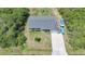 Aerial view of home displaying its roof, lawn, driveway with boat, and proximity to surrounding trees at 4229 Cockrell St, Port Charlotte, FL 33948