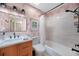 Charming bathroom with palm wallpaper, updated lighting, and tub with shower at 4229 Cockrell St, Port Charlotte, FL 33948