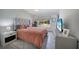 This bedroom features a gray tufted headboard, coral bedding, and natural light from the window at 4229 Cockrell St, Port Charlotte, FL 33948