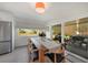 Bright dining room with a wooden table set for six and a view of an outdoor living space at 4229 Cockrell St, Port Charlotte, FL 33948