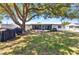 Spacious backyard with mature trees, golf cart, and inviting screened patio at 4359 Pocatella Ave, North Port, FL 34287