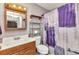 Bathroom features a wood vanity, framed mirror, and a stylish shower curtain, with a neutral color scheme at 4359 Pocatella Ave, North Port, FL 34287