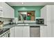 Well-lit kitchen features white cabinets, gray countertops, and stainless steel dishwasher at 4359 Pocatella Ave, North Port, FL 34287