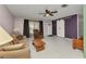 Spacious living room with a ceiling fan, tiled flooring, natural light, and sliding barn doors at 4359 Pocatella Ave, North Port, FL 34287