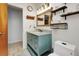 Bathroom featuring a granite topped blue vanity, a wood framed mirror with shelves, and a toilet at 4474 Ozark Ave, North Port, FL 34287