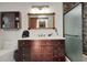 Modern bathroom features a wood framed mirror over a dark wood vanity, and a stone walled shower stall at 4474 Ozark Ave, North Port, FL 34287