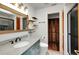 Bathroom featuring a blue vanity with granite top and a wood framed mirror, with shelves and a shower at 4474 Ozark Ave, North Port, FL 34287