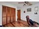 Bedroom featuring wood floors, ceiling fan and large closet with louvered wood doors at 4474 Ozark Ave, North Port, FL 34287