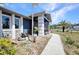 Exterior of a home, featuring a screened-in porch, stone accents, and charming landscaping at 4474 Ozark Ave, North Port, FL 34287