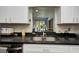 Close-up of the kitchen sink with granite countertops and white cabinets at 4474 Ozark Ave, North Port, FL 34287