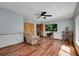 Bright living room featuring wood flooring, ceiling fan, closet and a large TV at 4474 Ozark Ave, North Port, FL 34287