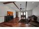 Cozy living room featuring wood floors, beamed ceilings, and modern entertainment center at 4474 Ozark Ave, North Port, FL 34287