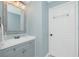 Well-lit bathroom featuring light blue walls, white trim and gray vanity at 4569 Kenvil Dr, North Port, FL 34288