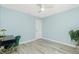 Well-lit bedroom featuring light blue walls, ceiling fan, and hard surface flooring at 4569 Kenvil Dr, North Port, FL 34288