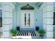 Inviting front entryway with double doors, decorative columns, and a stylish striped doormat at 4569 Kenvil Dr, North Port, FL 34288