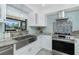 Modern kitchen features a stainless steel farmhouse sink, granite counters and stainless appliances at 4569 Kenvil Dr, North Port, FL 34288
