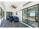 Screened-in porch featuring stylish furniture, a ceiling fan, and a sliding glass door at 4569 Kenvil Dr, North Port, FL 34288