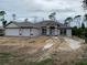 Charming single-story home with a three-car garage and stylish exterior lighting fixtures at 47 Tee View Rd, Rotonda West, FL 33947