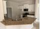 Bright kitchen features white cabinets, granite countertops, and stainless steel appliances at 47 Tee View Rd, Rotonda West, FL 33947