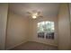 Cozy bedroom with a large window, ceiling fan, and neutral carpet at 4749 Oakley Rd, North Port, FL 34288