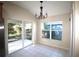 Bright dining area with sliding glass doors to the screened lanai and a modern chandelier at 4749 Oakley Rd, North Port, FL 34288