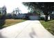Charming single-story home with a well-manicured lawn and a long driveway leading to an attached two-car garage at 4749 Oakley Rd, North Port, FL 34288
