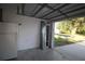 Garage with door open featuring an additional fridge and storm doors at 4749 Oakley Rd, North Port, FL 34288
