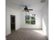 Bright main bedroom with carpet, a ceiling fan, and a large window overlooking the backyard at 4749 Oakley Rd, North Port, FL 34288