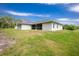 Back exterior of home with screened porch and well-maintained lawn at 5611 Ganyard Ave, North Port, FL 34291