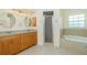 This primary bathroom features double sinks, separate shower and soaking tub at 5611 Ganyard Ave, North Port, FL 34291