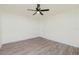 This bedroom features a ceiling fan, neutral walls, wood-look floors, and a bright window at 5611 Ganyard Ave, North Port, FL 34291