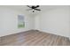 This bedroom features a ceiling fan, neutral walls, wood-look floors, and a bright window at 5611 Ganyard Ave, North Port, FL 34291