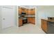 Kitchen with stainless steel oven, microwave, wood cabinets, granite countertops, and tile floors at 5611 Ganyard Ave, North Port, FL 34291