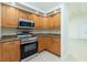Modern kitchen featuring stainless steel appliances and granite countertops with wood cabinets at 5611 Ganyard Ave, North Port, FL 34291