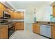 Spacious kitchen showcasing granite counters, wood cabinets, stainless steel appliances, and tile floors at 5611 Ganyard Ave, North Port, FL 34291