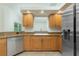 Kitchen featuring wood cabinets, granite countertops, stainless steel dishwasher, and tile flooring at 5611 Ganyard Ave, North Port, FL 34291