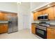 Kitchen with stainless steel appliances, wood cabinetry, granite countertops, and a tile floor at 5611 Ganyard Ave, North Port, FL 34291