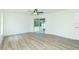 This living room features light walls, vinyl plank flooring and a sliding glass door at 5611 Ganyard Ave, North Port, FL 34291